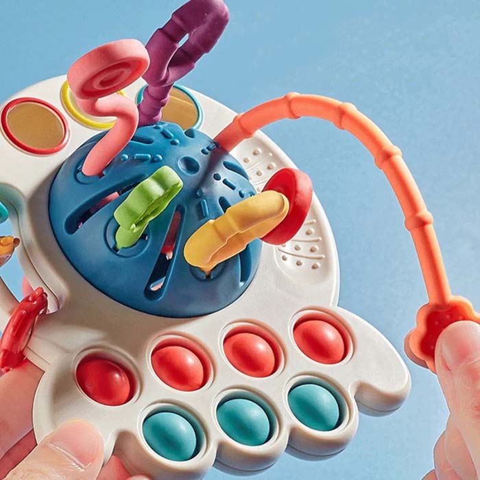 Il giocattolo ha molte funzioni (bottoni da premere, corde da tirare, anelli, ecc.) e texture che stimolano lo sviluppo sensoriale!